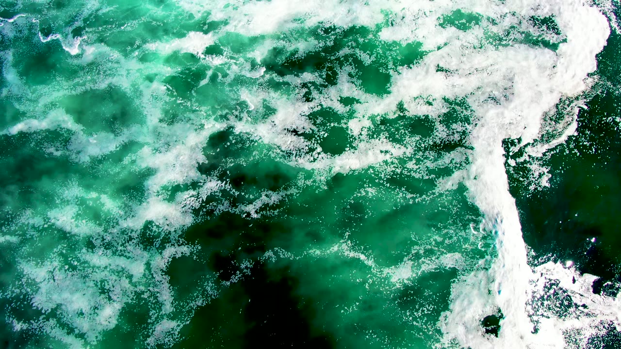 Overhead La Bocana ocean frame with dense white foam along the right side and green water filling the rest, with no visible people.