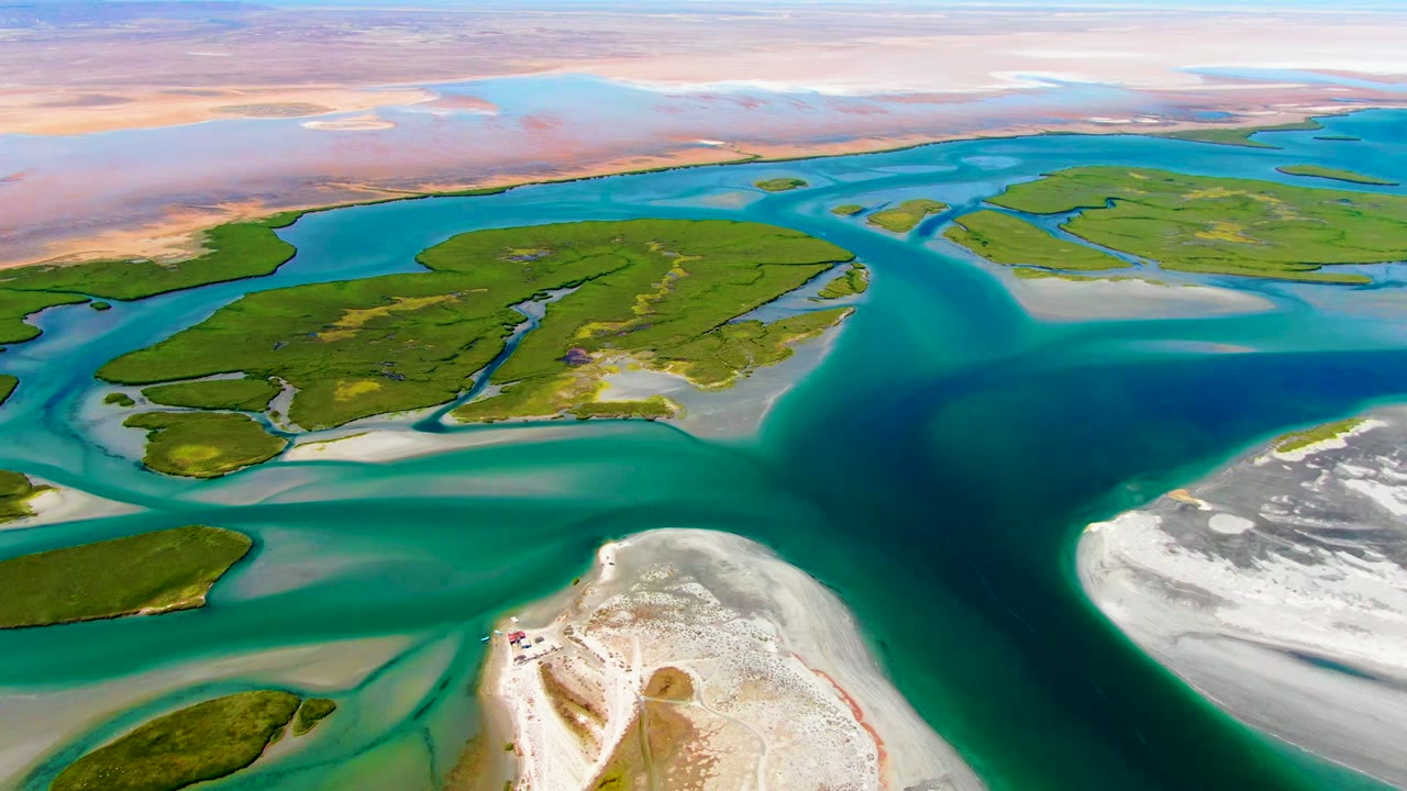 At 0:02, the La Bocana aerial holds on green islands, branching turquoise water, pale sand deposits, and a bright white foreground sand spit with no visible people.