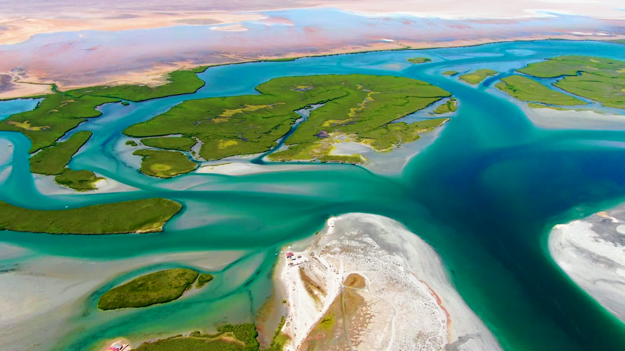 High aerial view of green coastal islands divided by blue tidal water.