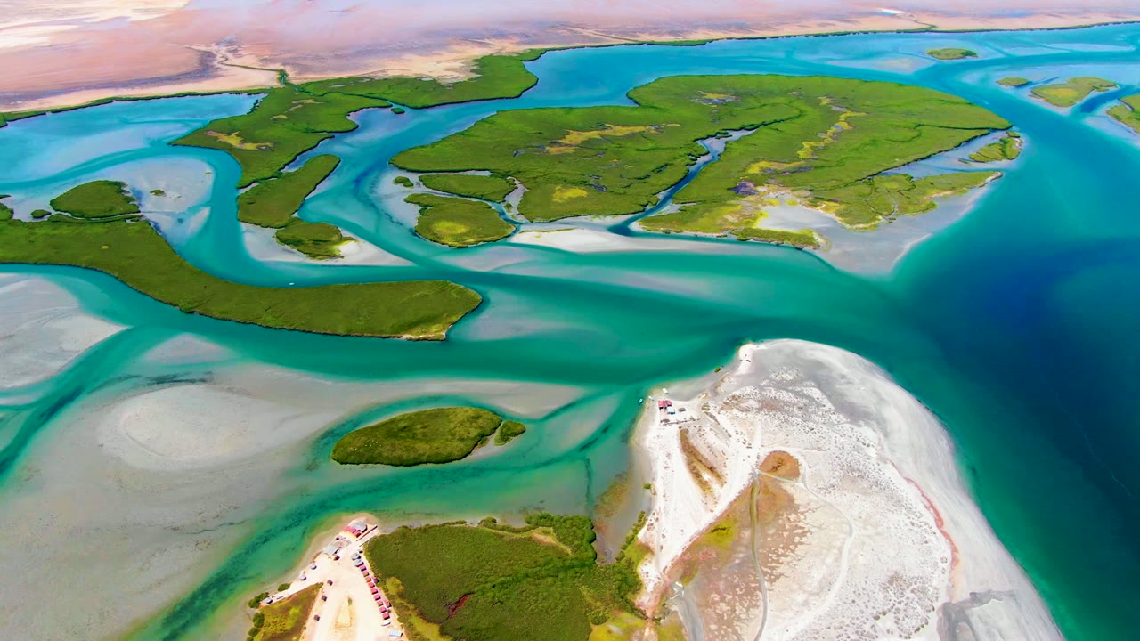 Drone view of green islands separated by blue and turquoise tidal water.
