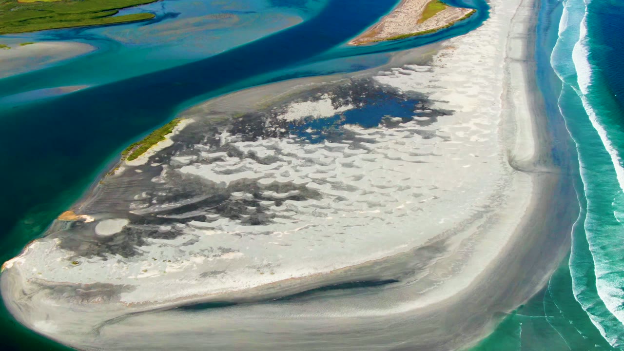 Sandbar edge with lagoon channel and breaking ocean waves