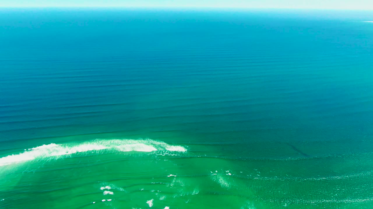 At two seconds, the overhead La Bocana view keeps open ocean across the frame while a bright white foam line arcs through the lower third, with no boats, shoreline, or visible people.