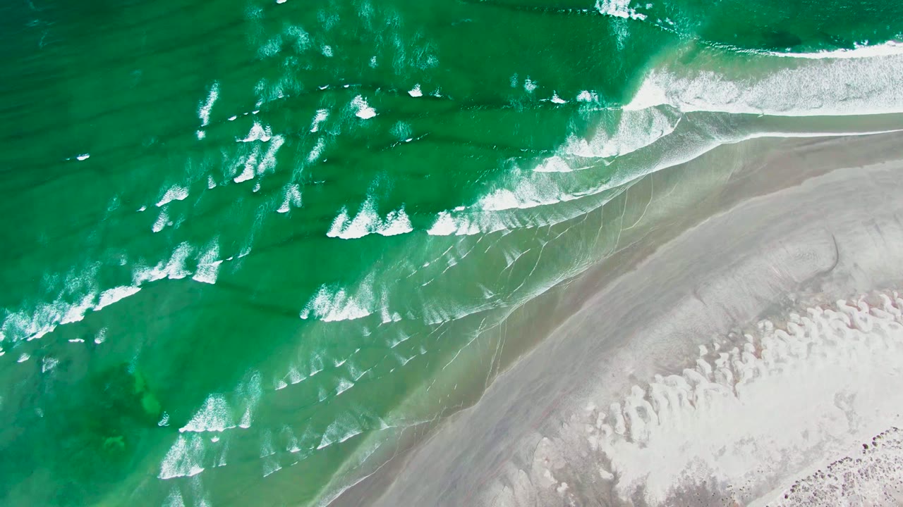 White foam lines crossing shallow green water