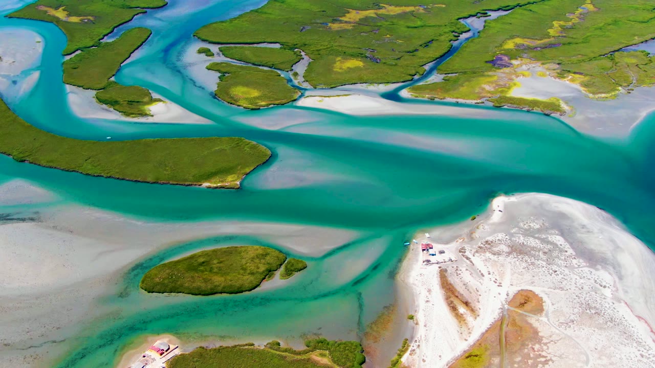 Aerial view of turquoise water, green islands, and a bright sandy shoreline.
