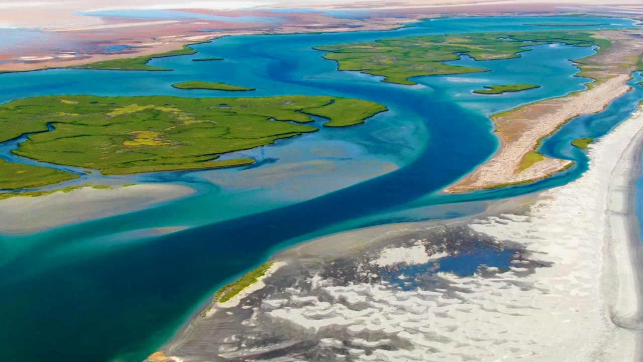 Drone view of delta islands and sandbars beside blue and turquoise water