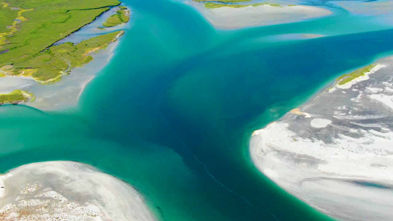 Overhead coastal channel with blue water and pale sandy shores.