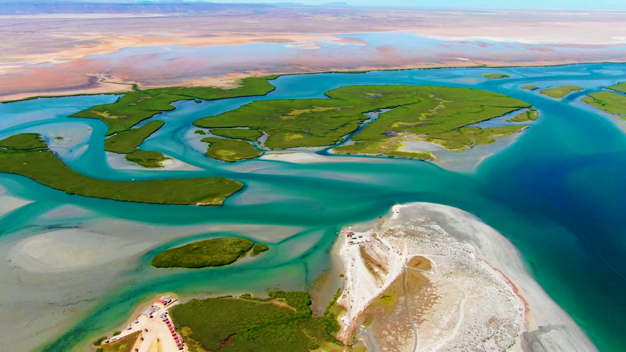 Elevated coastal view with green islands, sandbars, and bright blue water.