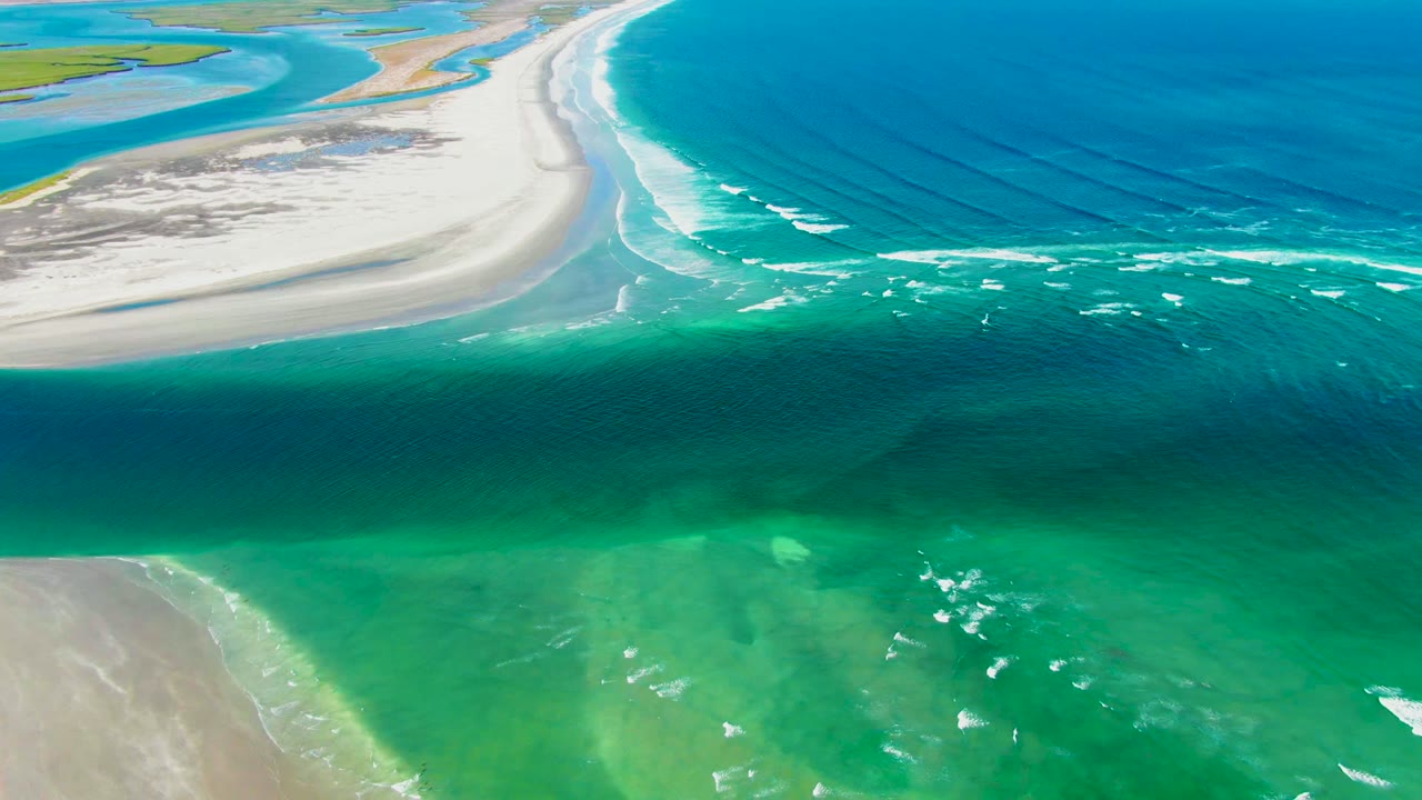 Overhead coastal water with whitecaps moving across green shallows