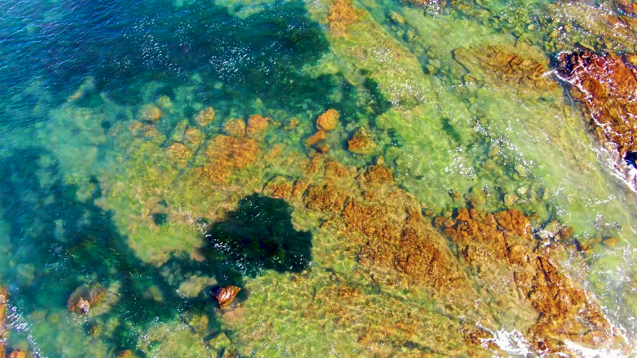 Turquoise water lapping across submerged rocks