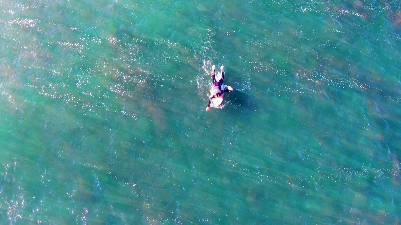 Swimmer floating through clear ocean from above