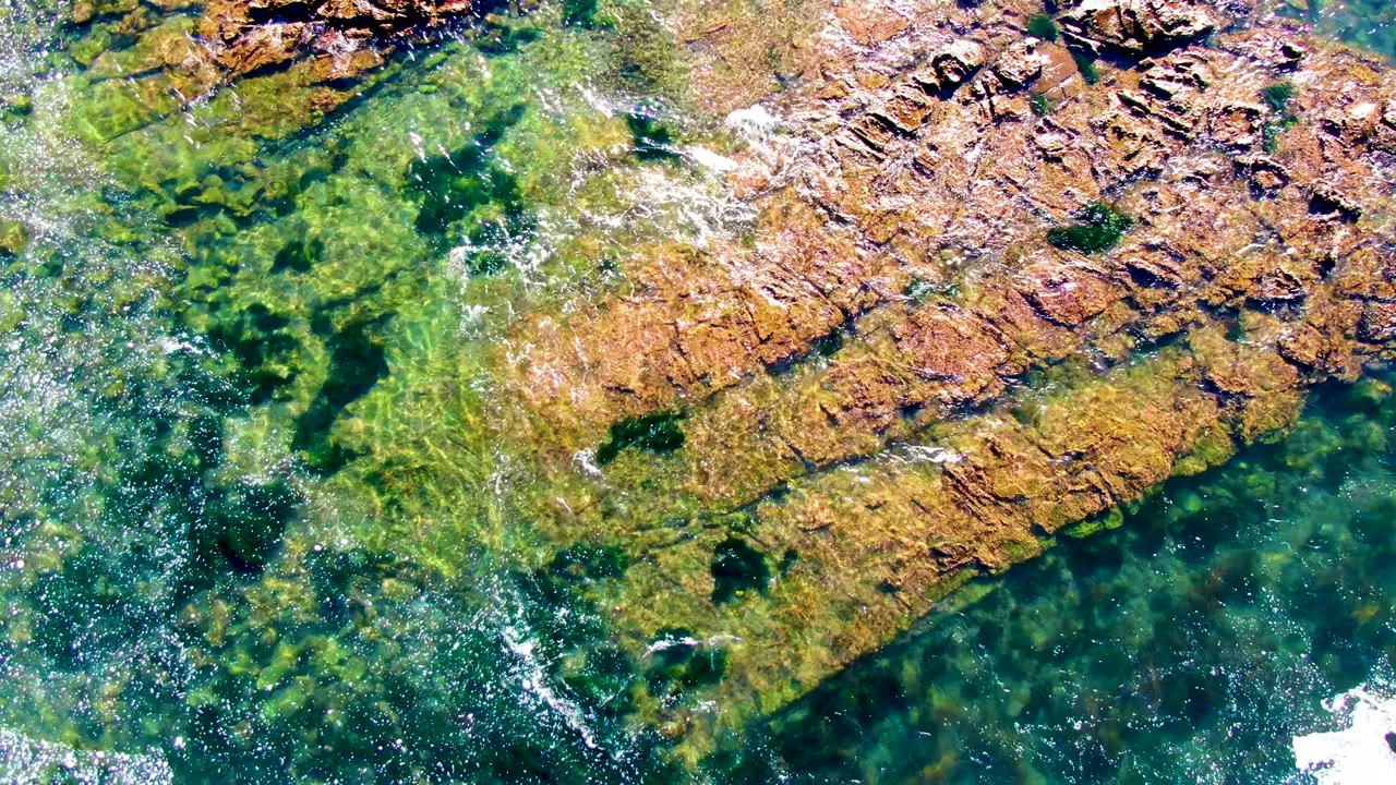 White foam drifting across rocky shallow water