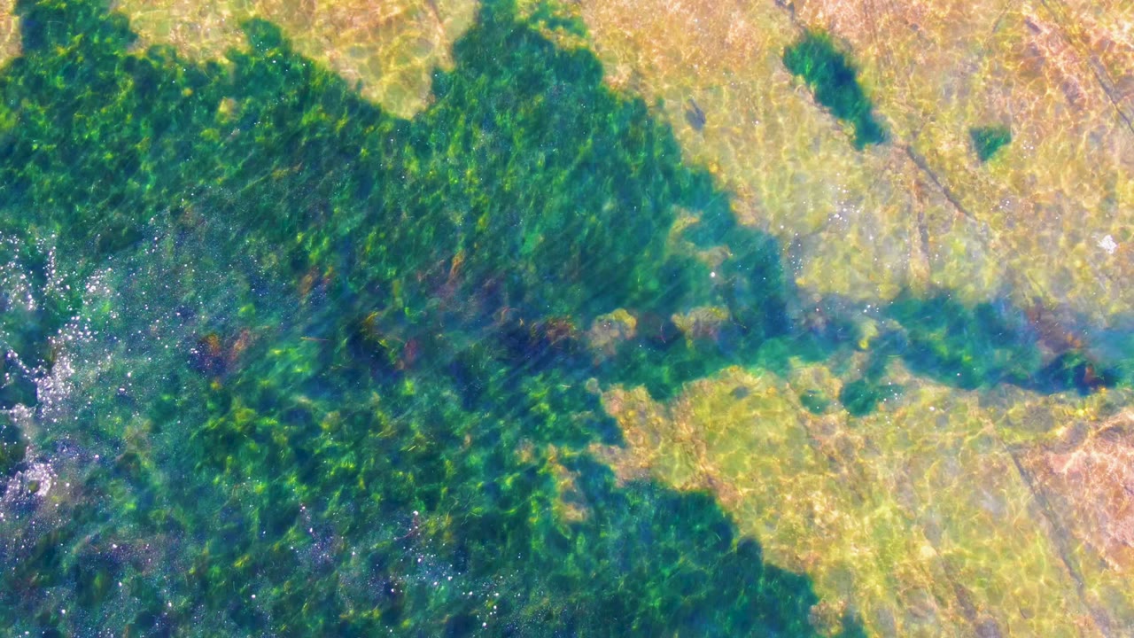 La Bocana aerial frame showing a broad smoke layer over green vegetation, pale farmed ground, and blue-green wet areas, with no visible people.