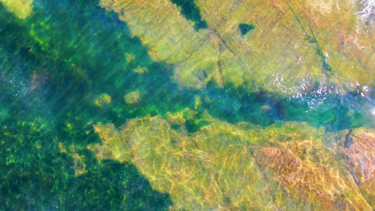 Sunlit underwater rock with darker green water channel