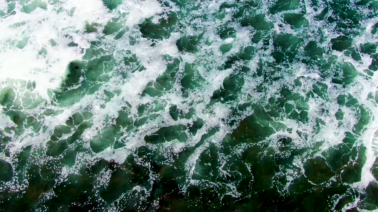 Foamy wave patterns on green sea surface
