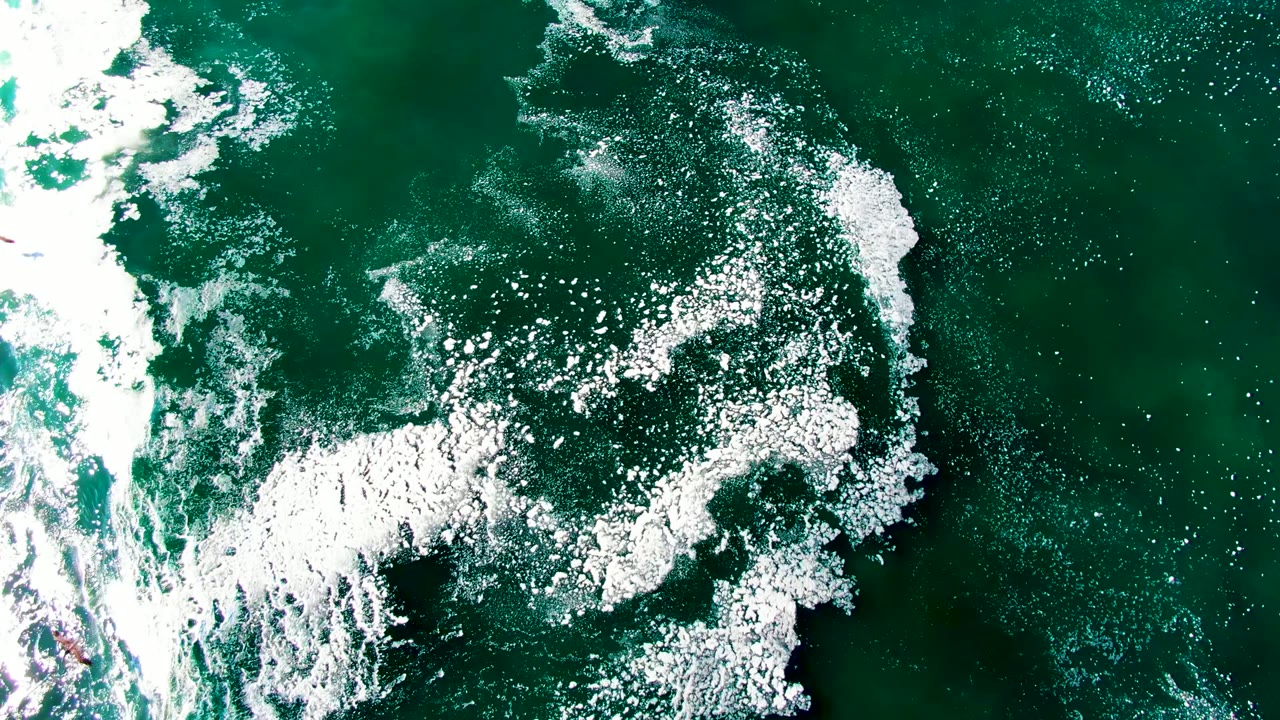 Foam band and scattered bubbles on turquoise water