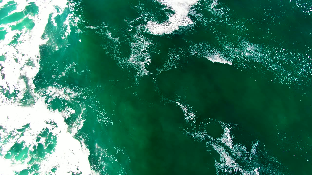 Overhead green ocean with bright white foam bands.