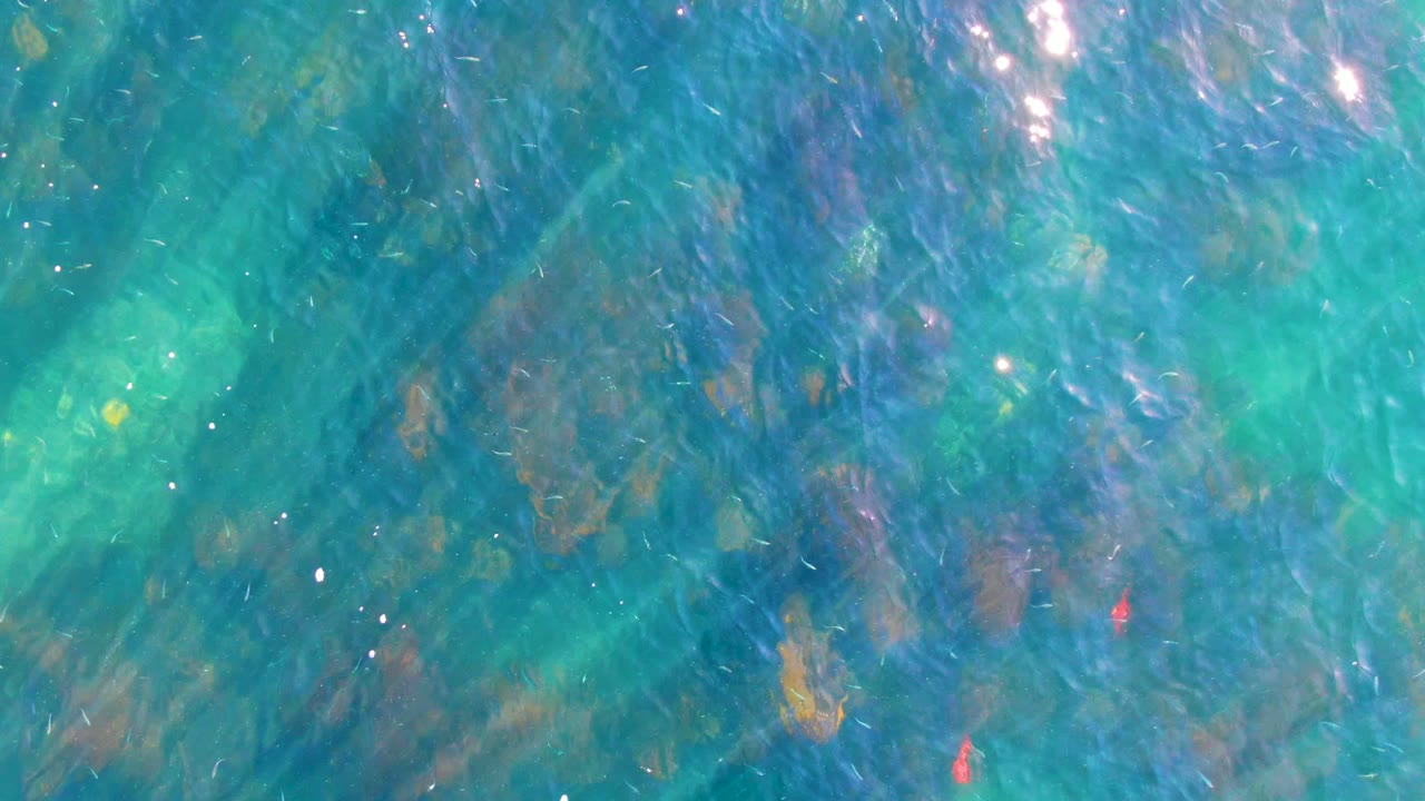 Blue-green water with rocks below the surface