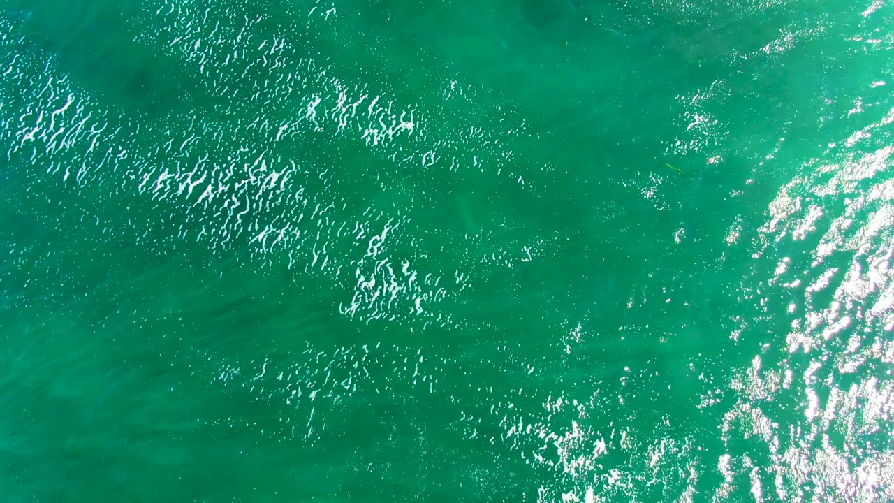 Green-blue ocean water in La Bocana, Baja California Sur, shows scattered white ripples, a strong highlight along the right edge, and no visible people.