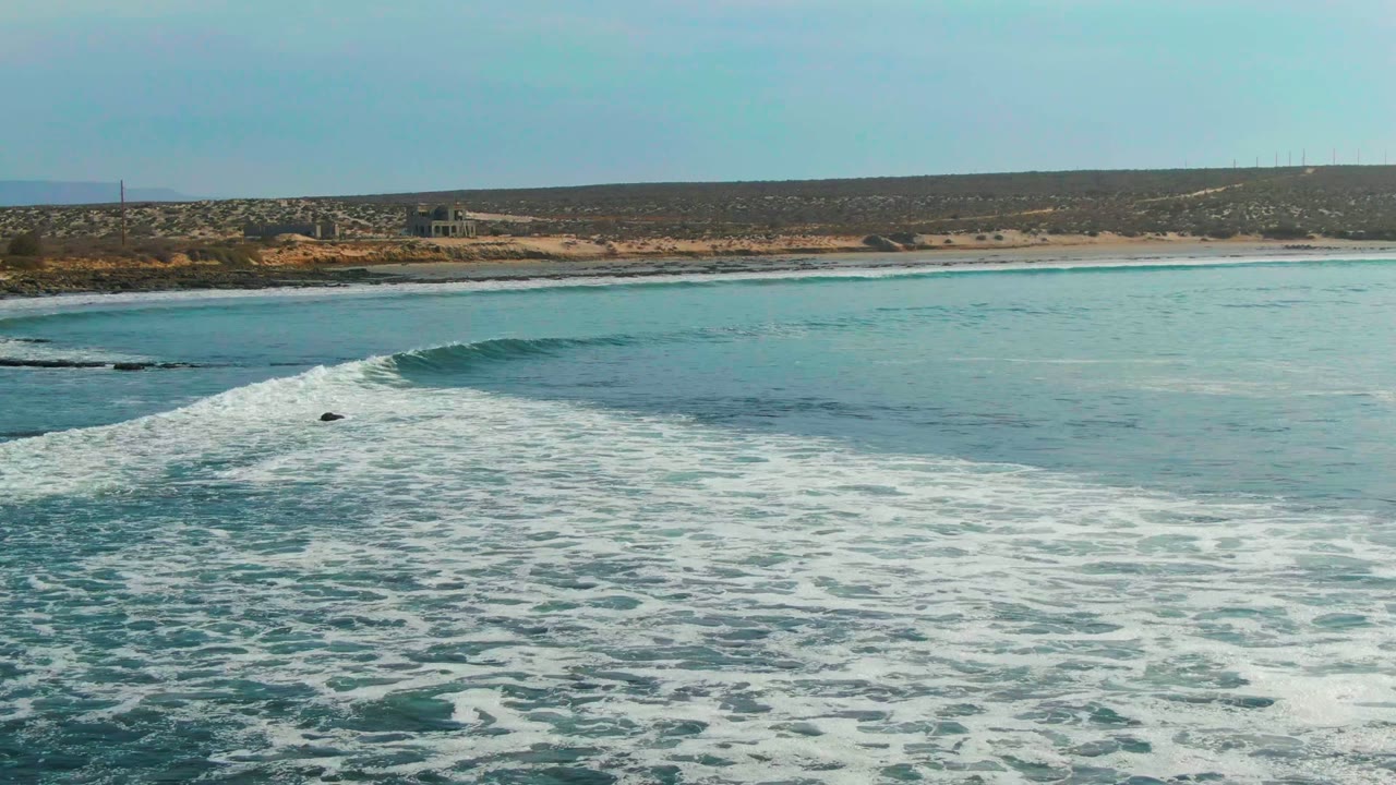 Ocean swell cresting with foam across blue water