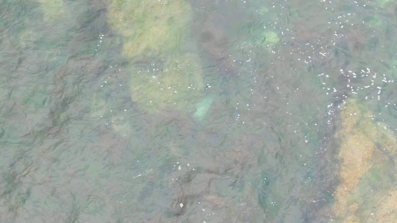 A top-down La Bocana water detail shows green-blue shallow water, darker seabed streaks, and bright surface specks, with no visible people.