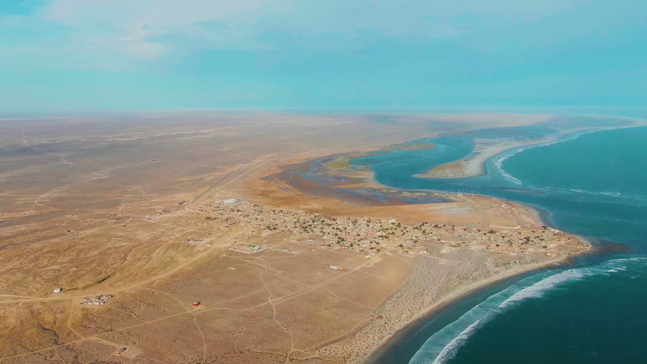 High aerial view of La Bocana settlement beside lagoon and ocean.
