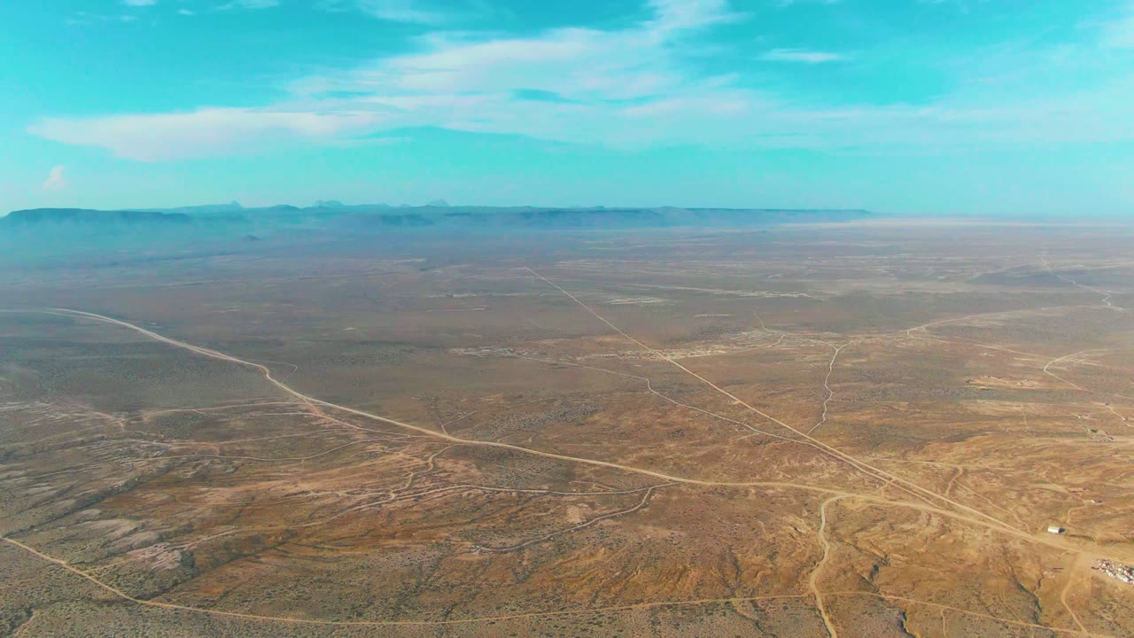 Aerial desert landscape with intersecting dirt roads.