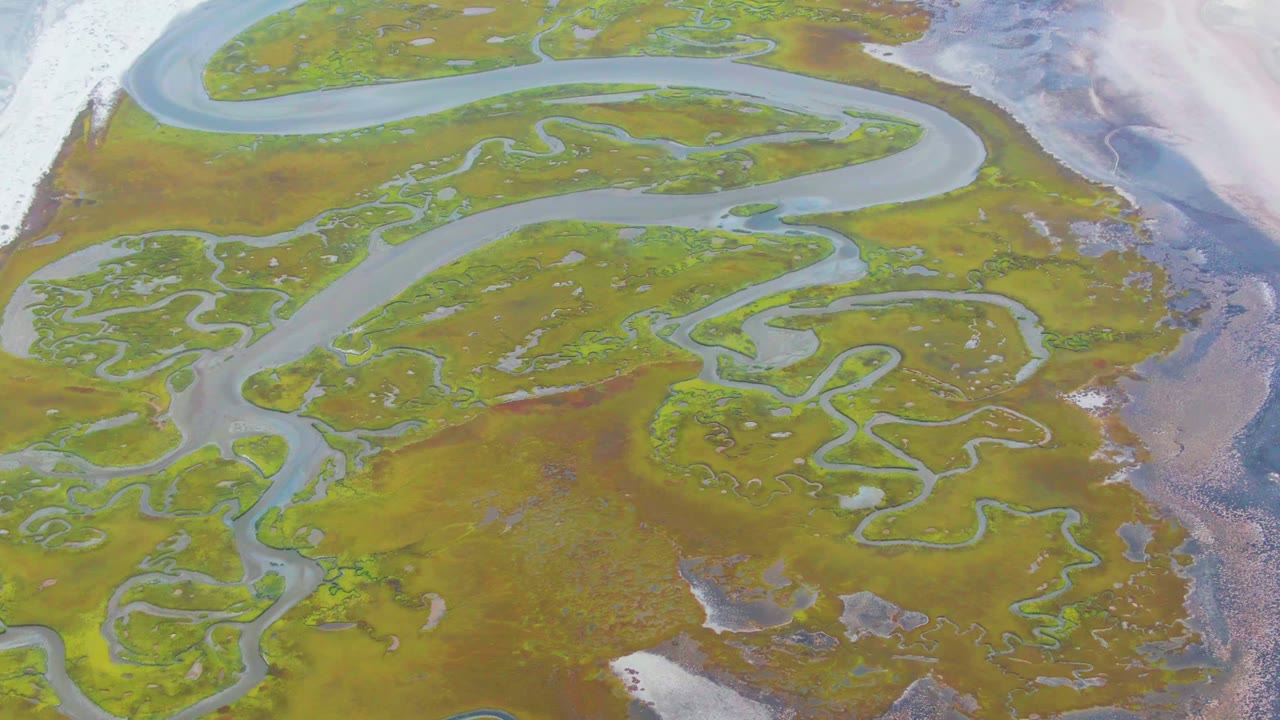Overhead river bends and marsh channels with pale ice nearby