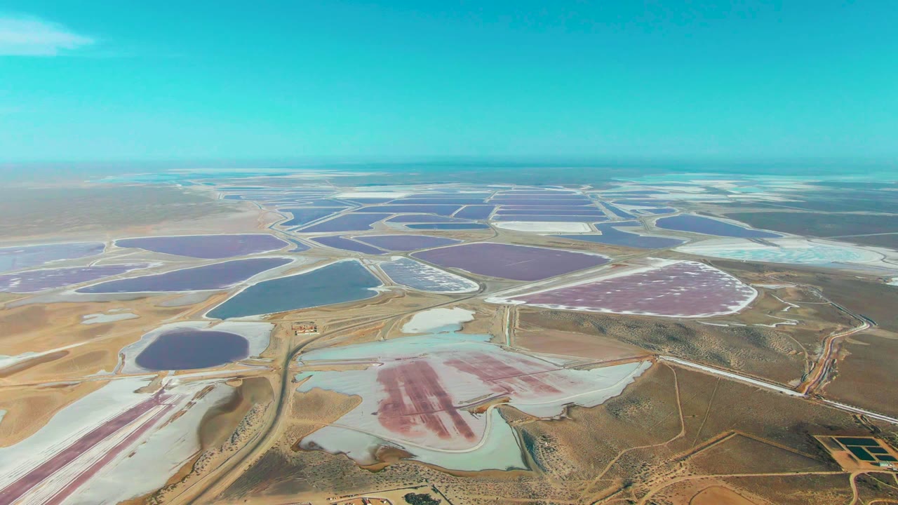Wide aerial of pink, purple, blue, and white salt ponds.