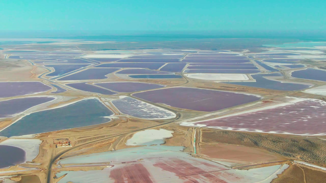 Colored salt ponds with roads and a small structure near the lower frame.