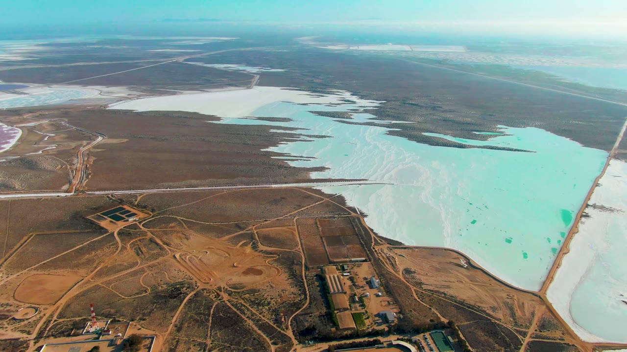 Salt evaporation ponds and dry earth seen from a high aerial angle.