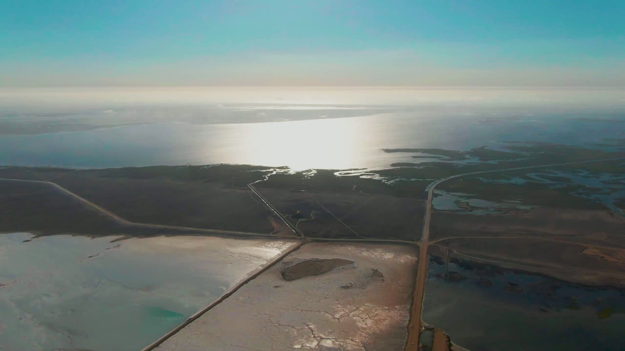 High aerial view of dry flats and shimmering water near the coast