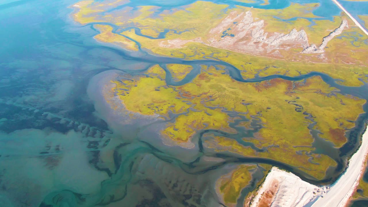 Overhead water channels curve through yellow and green terrain.