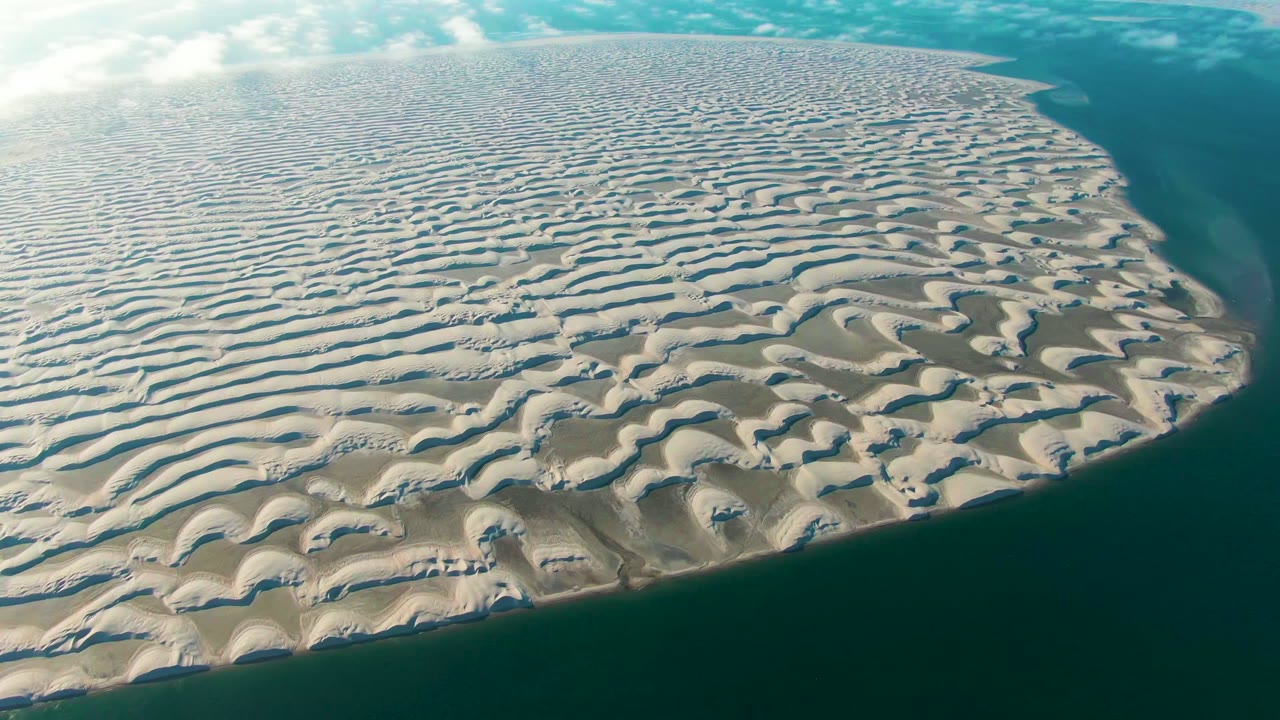 Third frame holds a broad aerial composition of wavy sand patterns beside blue-green water in Guerrero Negro, Baja California Sur, with no visible people.
