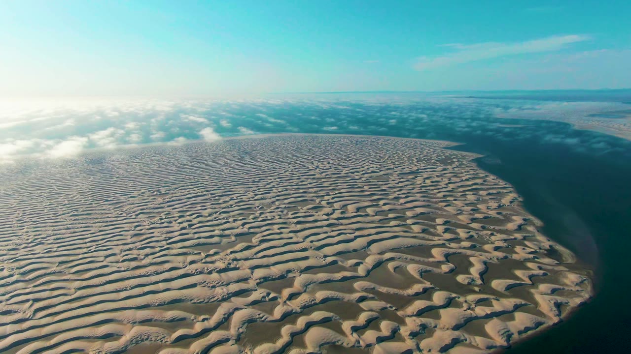 Two seconds into the clip, sunlit rippled sand dominates the foreground in Guerrero Negro, Baja California Sur, while a band of low clouds sits beyond the dune and no people are visible.