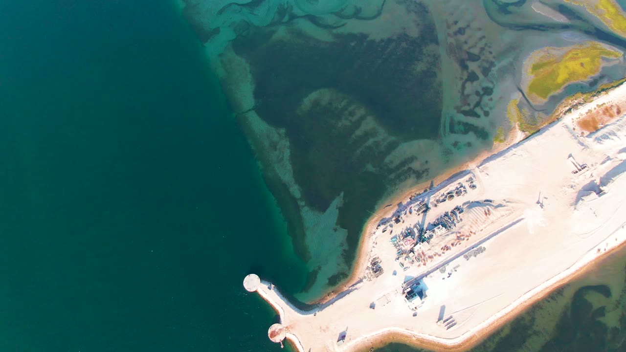 The third frame shows the Guerrero Negro causeway from overhead, with bright pale ground, clustered small structures, dark green-blue water, yellow-green shallow patches, and no visible people.