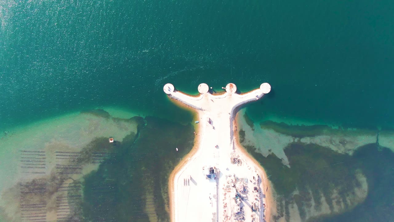 T-shaped pier centered below open water with seabed visible near shore.