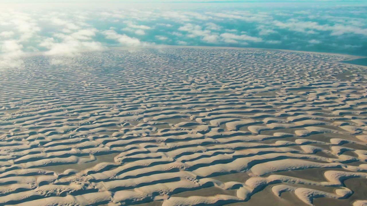 Opening frame of wavy sand dunes in Guerrero Negro, Baja California Sur, with soft cloud cover above and no visible people.