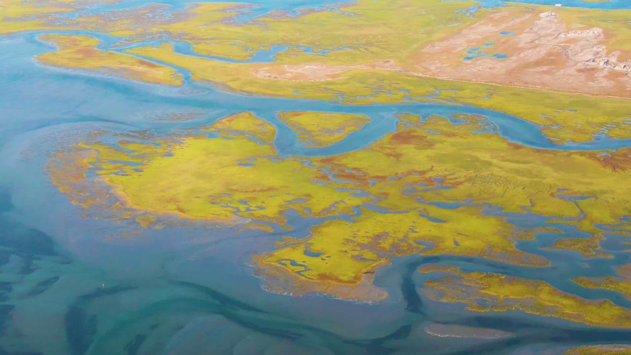 High aerial view of meandering blue waterways and yellow-brown land.