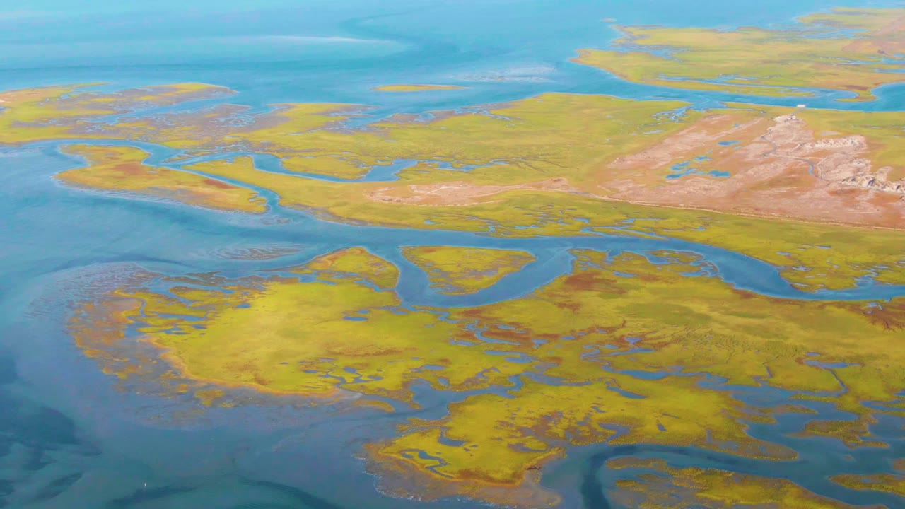 Marsh islands and winding water channels beneath open blue water