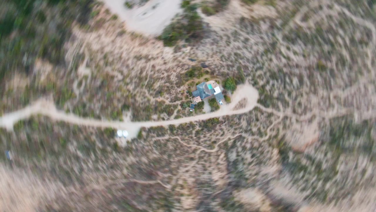 Aerial view of desert cabin beside winding road