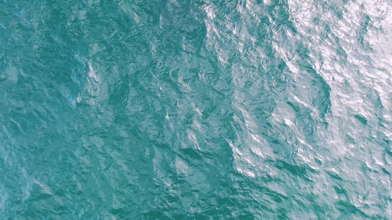 Turquoise ocean surface at Shipwrecks, Baja California Sur, with dense white reflection and small whitecap texture along the right side, and no visible people.