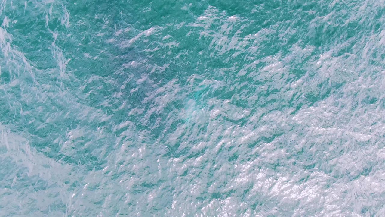 White foam patterns over blue-green ocean water.