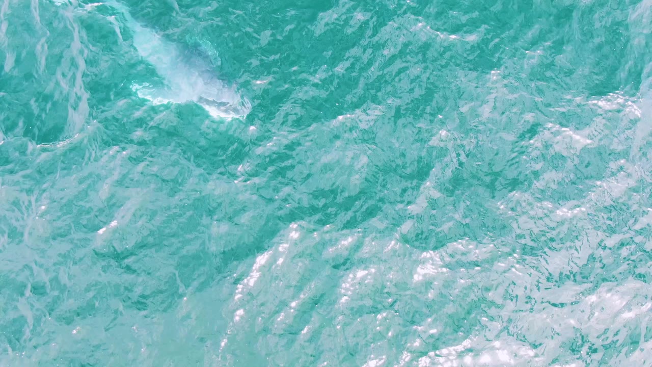 Turquoise ocean water fills the frame at Shipwrecks, Baja California Sur, with pale streaks of foam and no visible people.