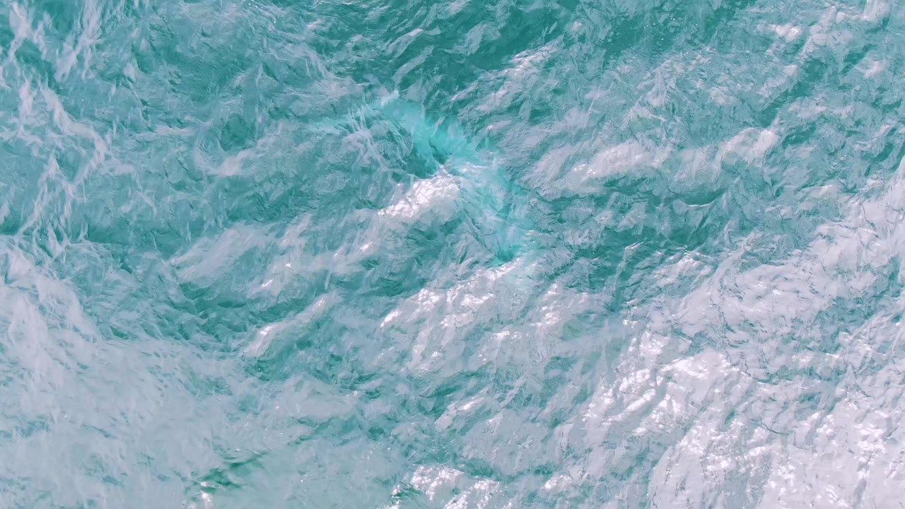 Textured ocean water with pale foam trails