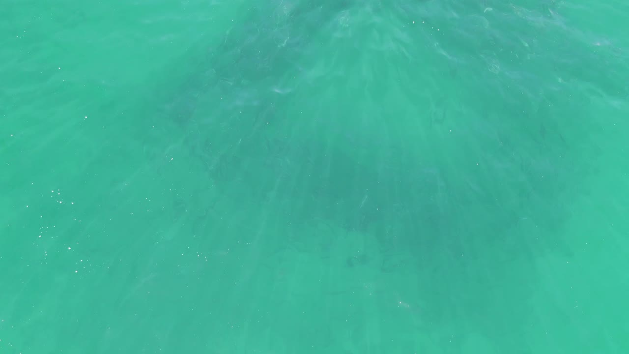 Second frame shows clear green-blue ocean surface at Buzzards Beach, Baja California Sur, with soft ripple streaks and no visible people.
