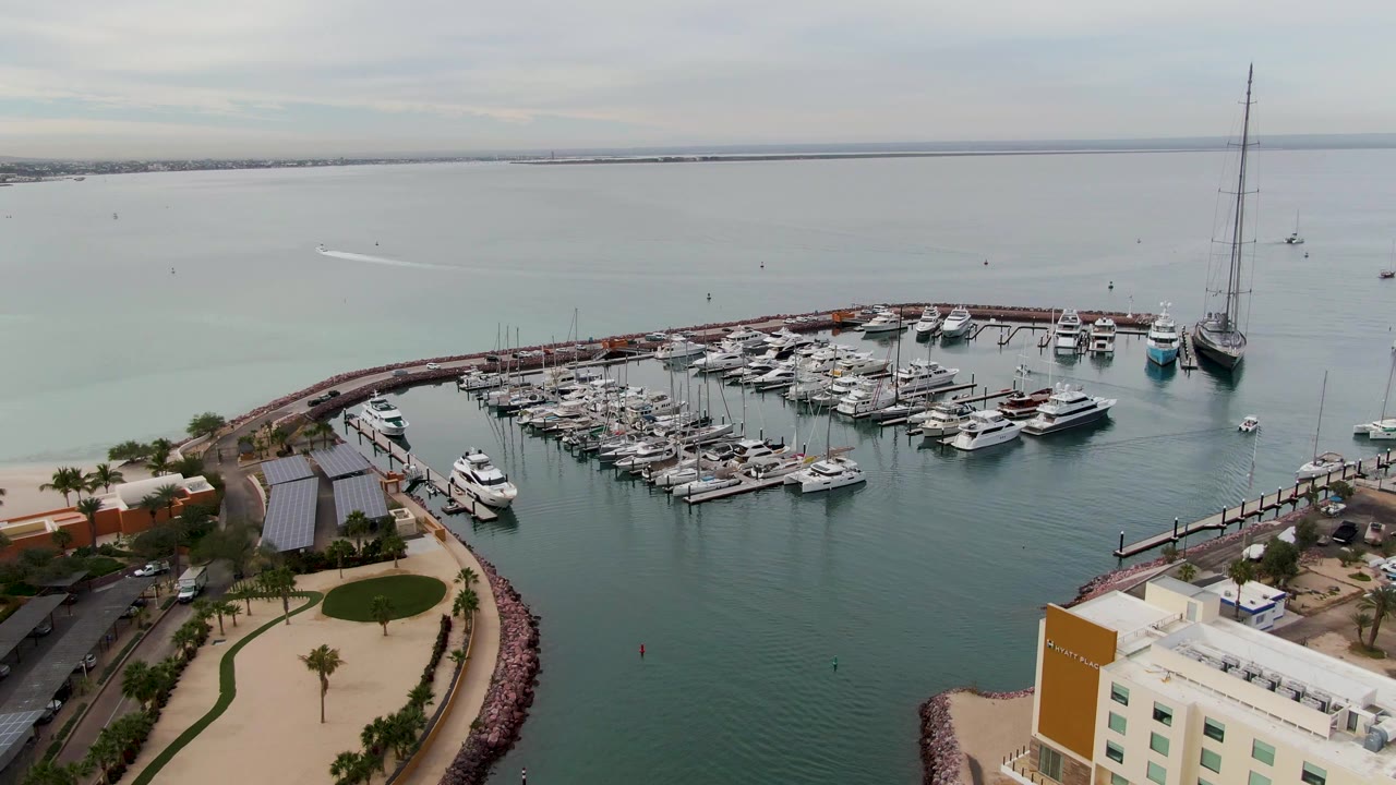 Drone view of boats and yachts moored in a curved marina.