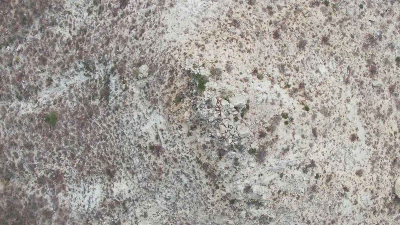 Overhead view at Punta Gorda Beach, Baja California Sur, with the small light-colored object slightly farther across the pale rocky terrain and no visible people.