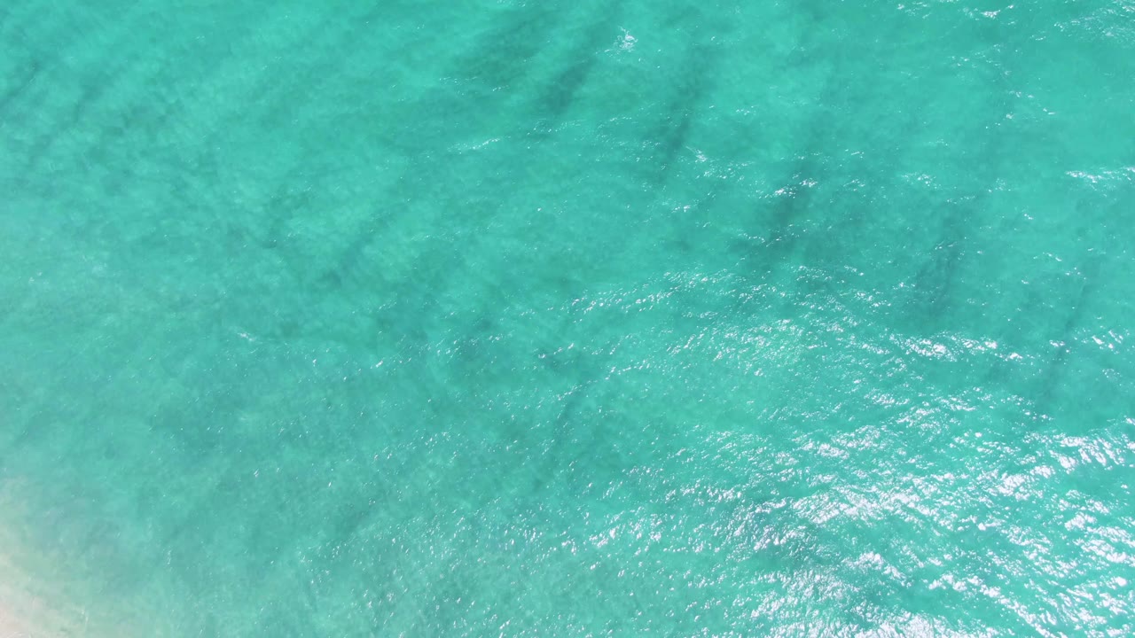 Turquoise shallow ocean water with darker underwater shadow bands