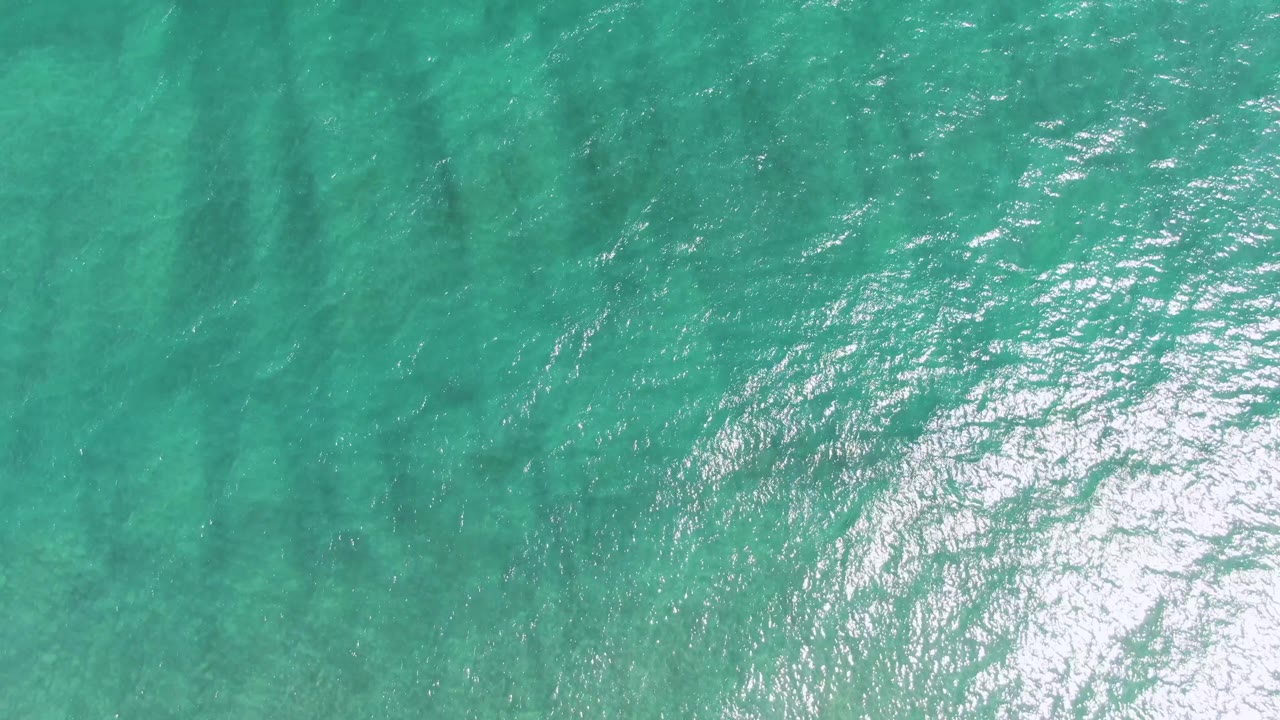 Puerto Los Cabos Beach water fills the frame with turquoise ripples, brighter reflection near the lower edge, and no visible people.