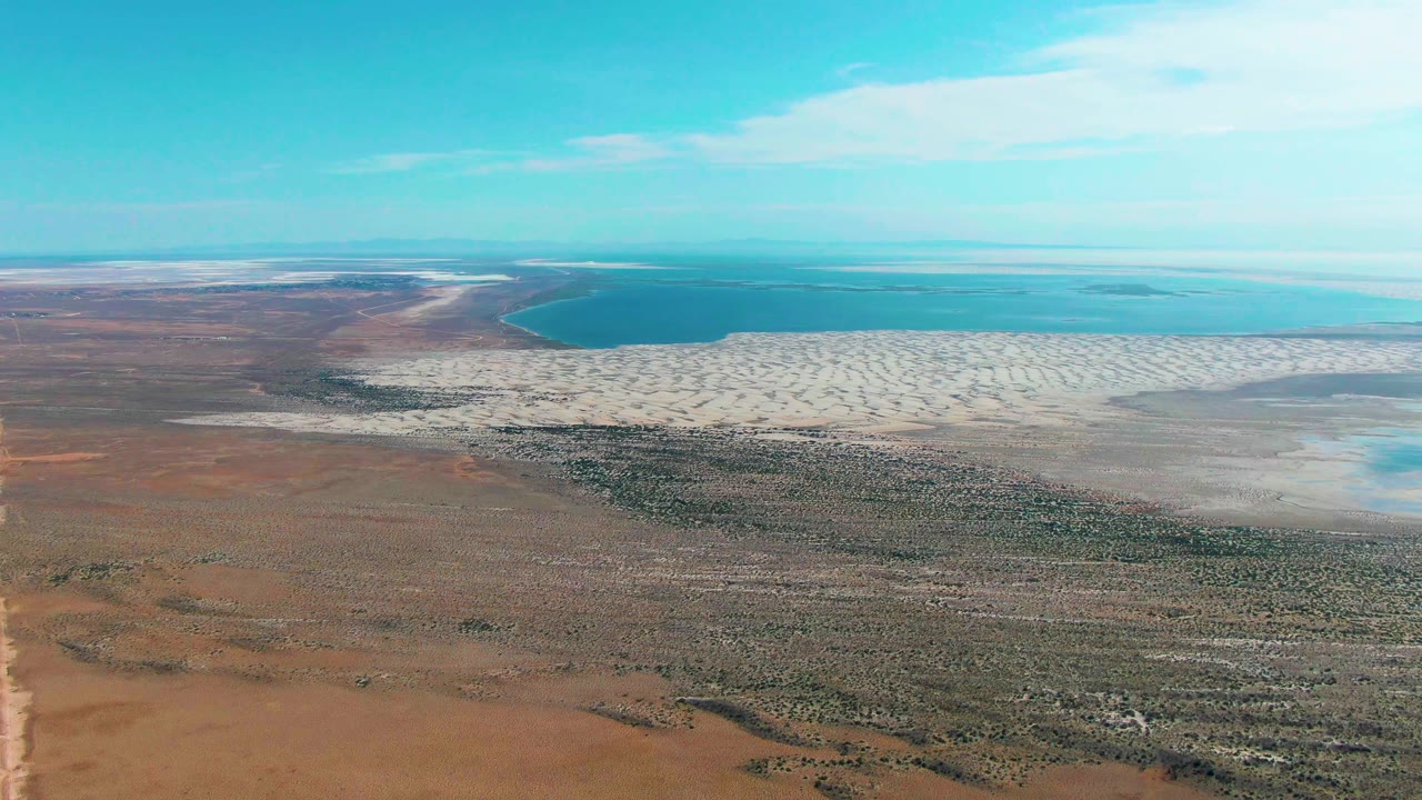 Aerial salt flat and water view with less of the road visible.
